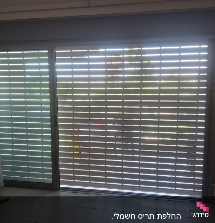 תריסי אלומיניום על חלון זכוכית גדול